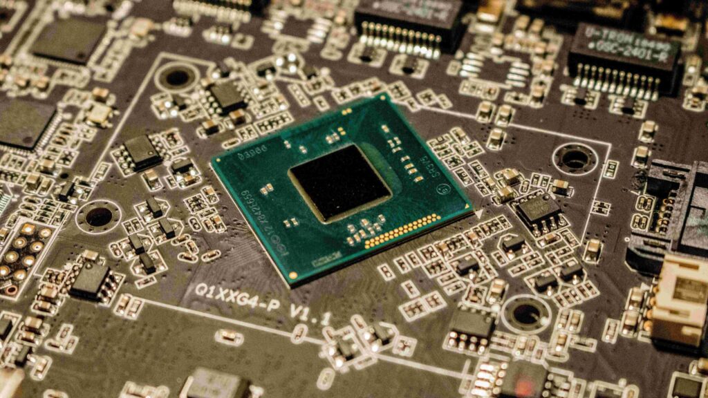 A close-up shot of a small, green System-on-a-Chip (SoC) embedded in a black circuit board, surrounded by other electronic components.
